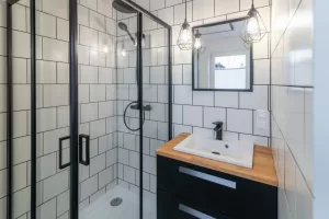 Modern Bathroom With A Washbasin And A Shower Cubicle. White Til